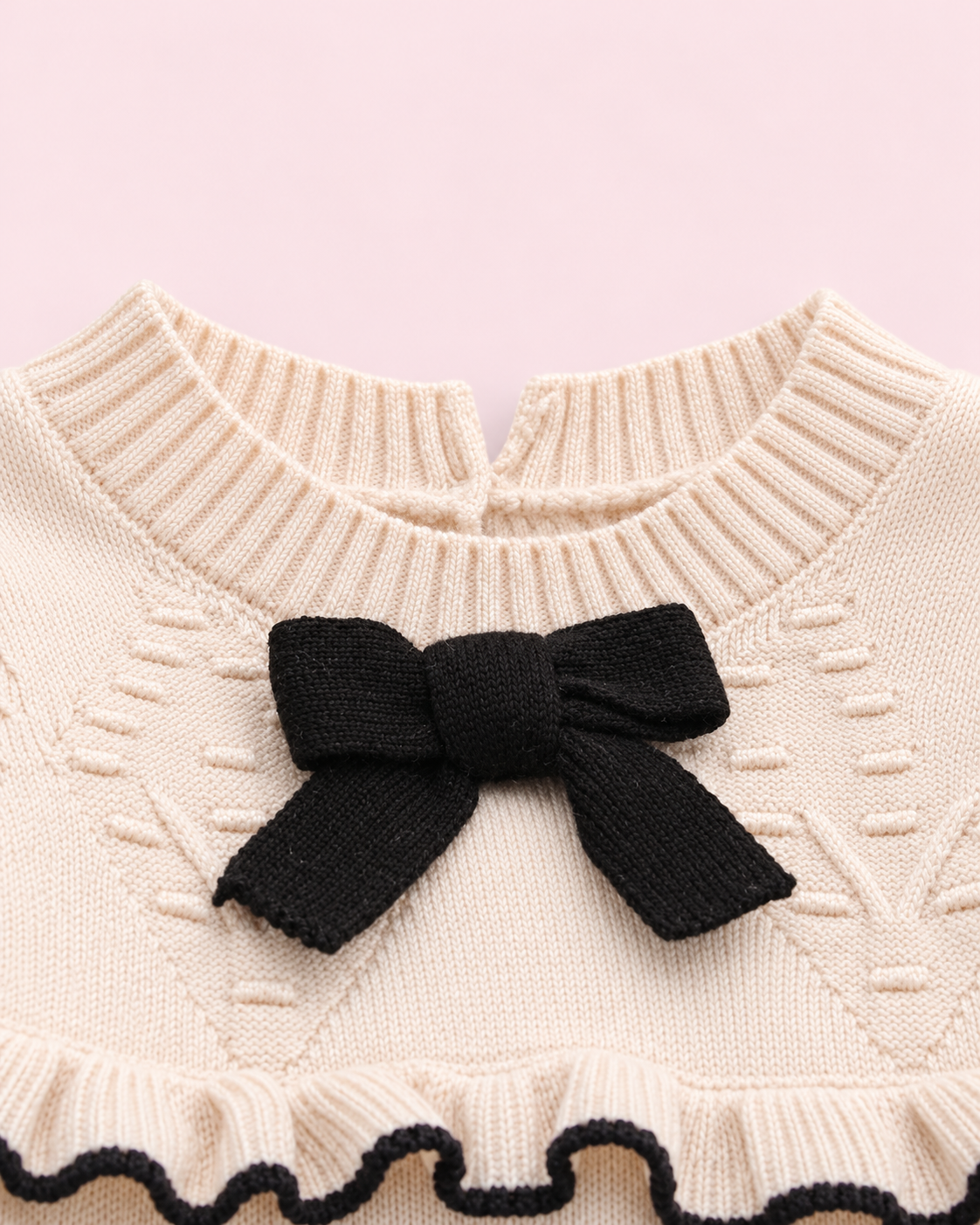 Close-up of black bow and raised knit detailing