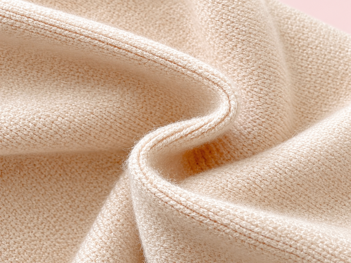 Beige knitted baby romper fabric detail on blush pink