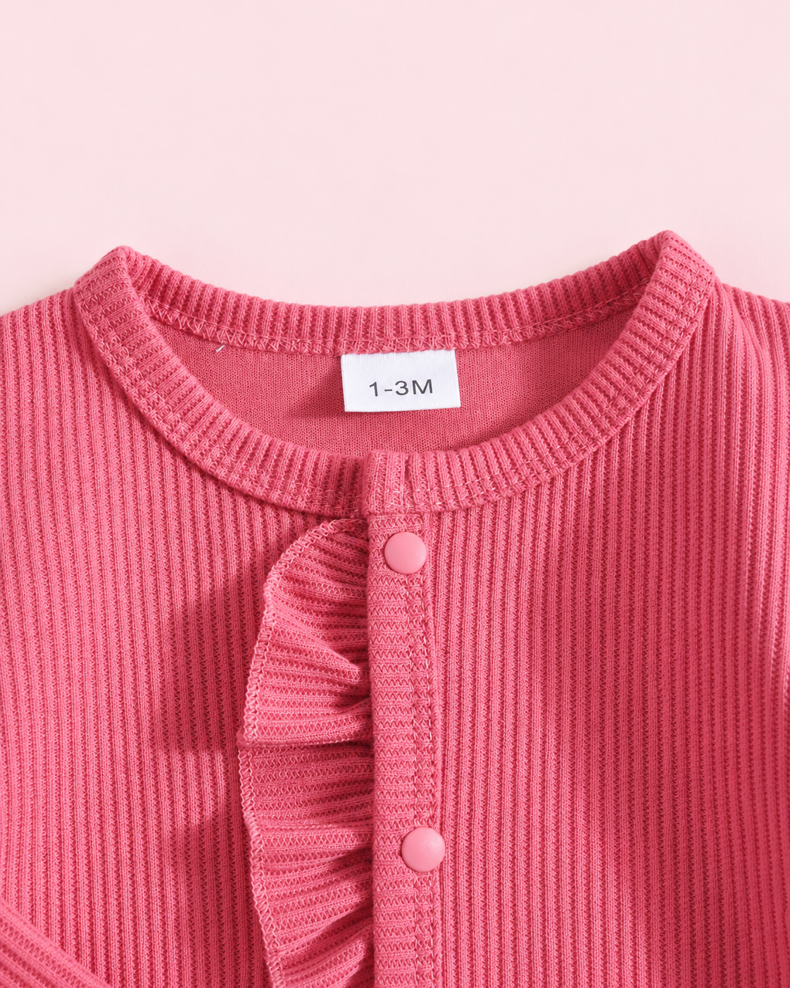 Hot pink ribbed romper neckline and ruffle snap placket detail